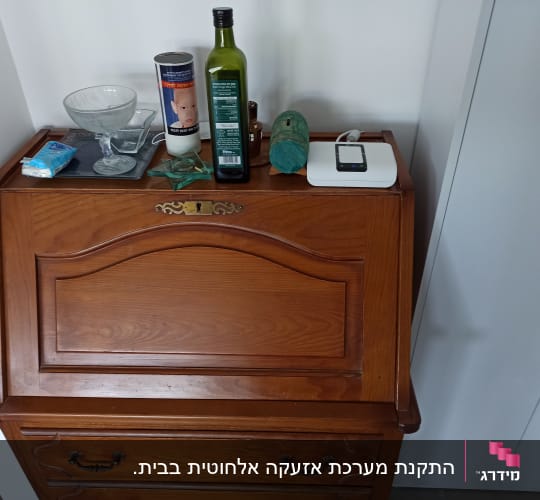 מכשיר לבן עם כבל על שידה מעץ